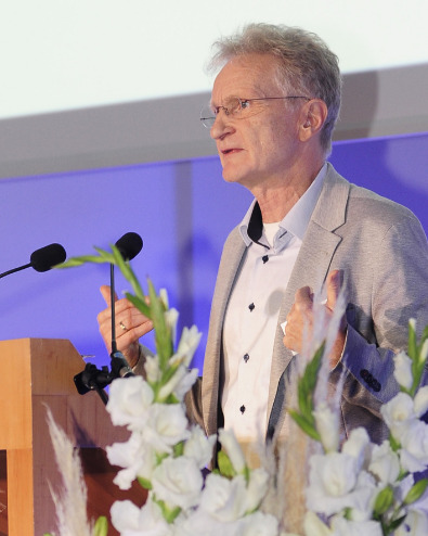 Ein Mann steht auf einem Podium und hält eine Rede. 