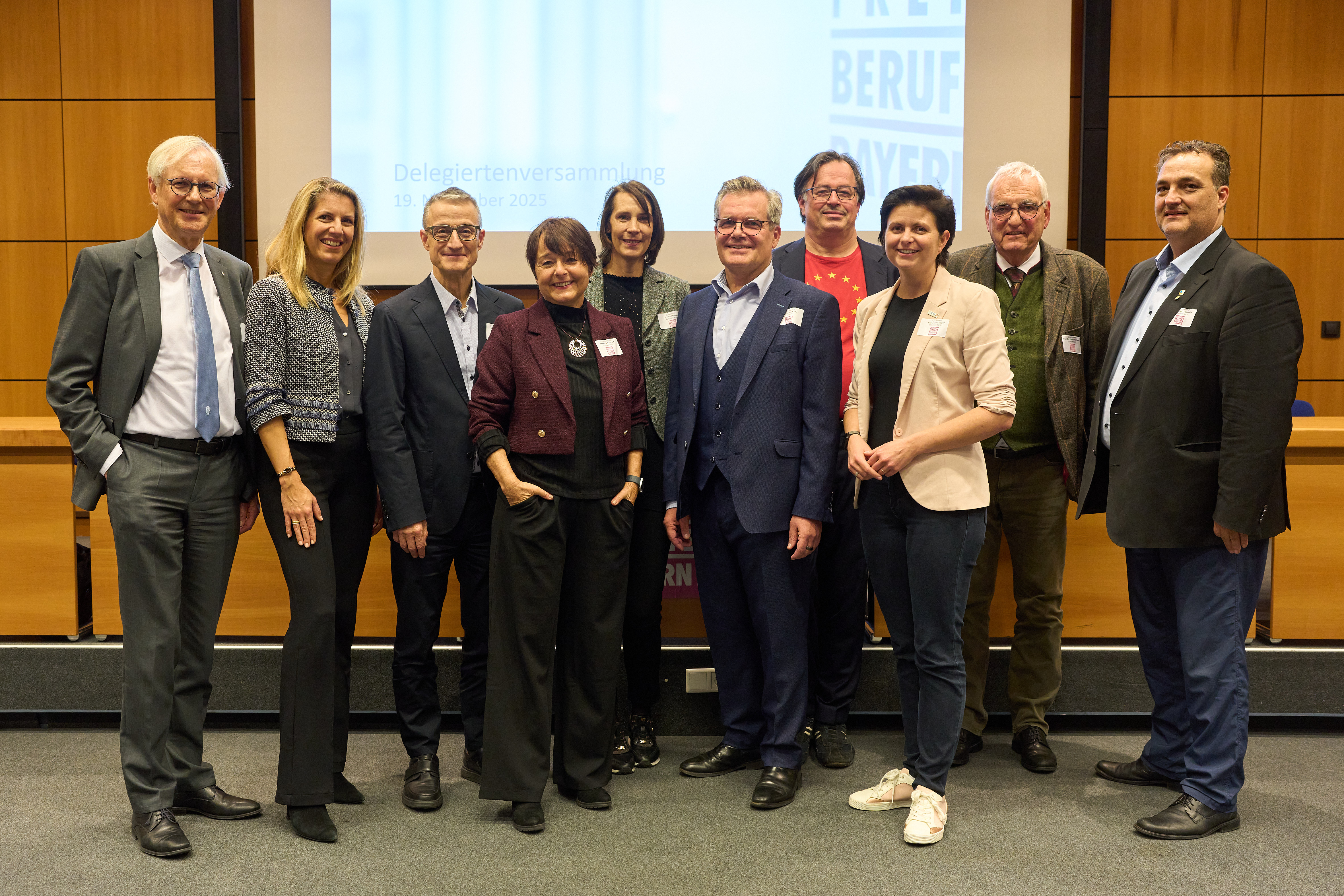 Zehn Personen stehen vor dem Podium.